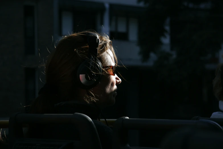 a man wearing headphones sitting in the sun