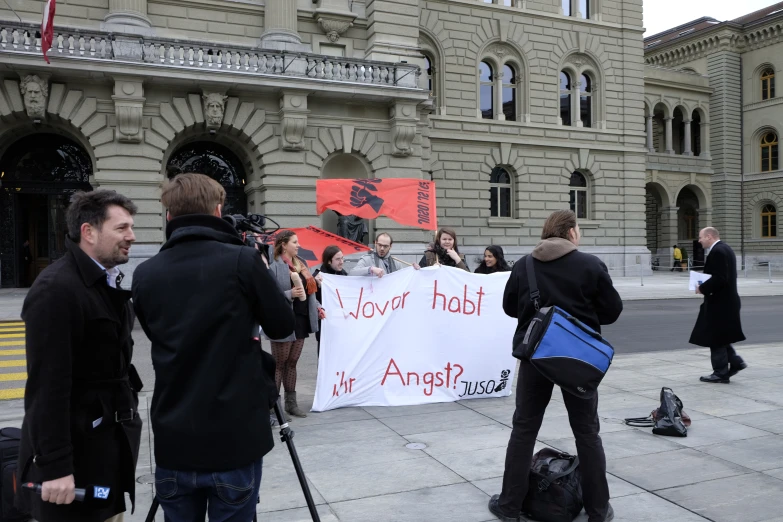 people holding up signs and camera equipment on the street