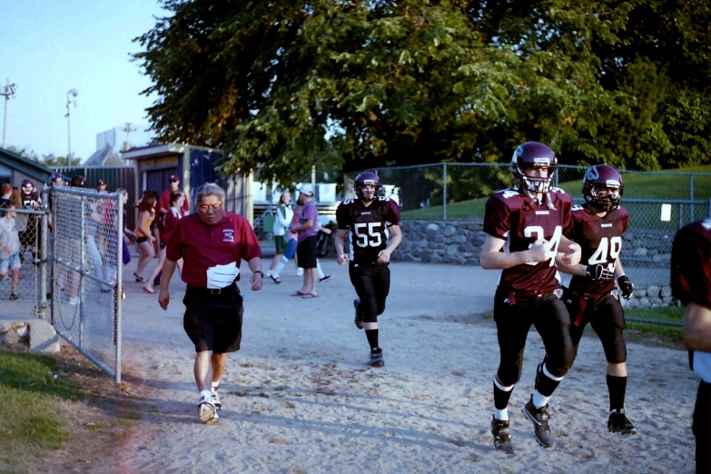 football players run onto the field at a game