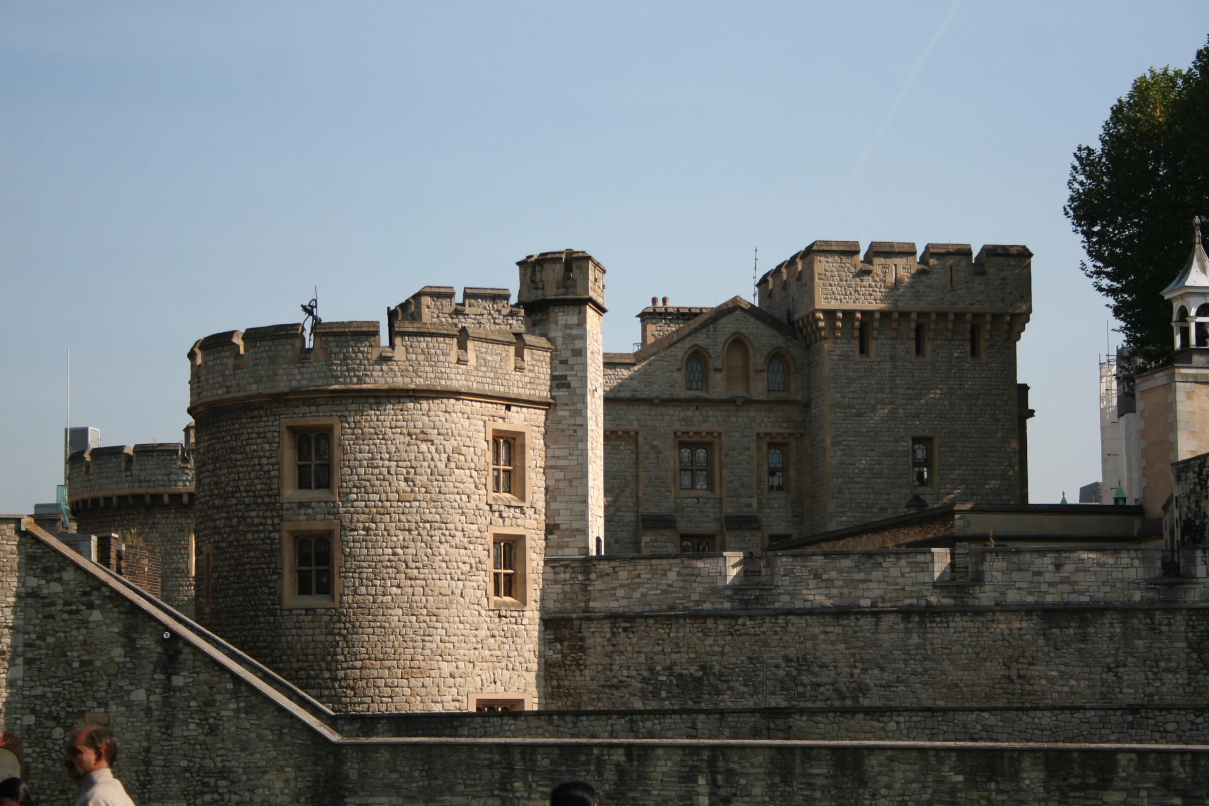 people walk around the gated entrance to an old castle