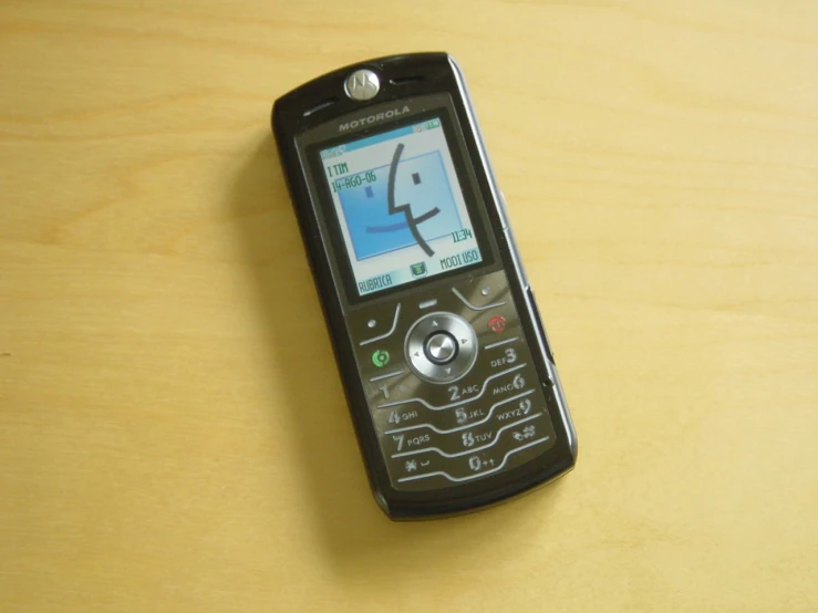 a cell phone sitting on a wooden surface with an image drawn out on the screen