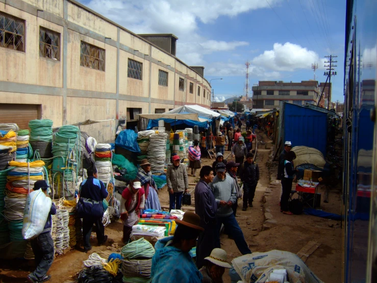 people and farmers market in the background with shops