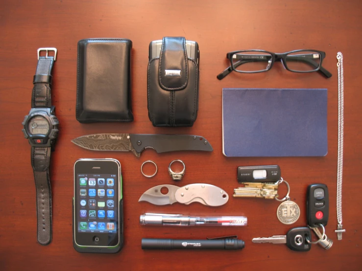 an assortment of accessories that include watch, sunglasses, cellphone and keys