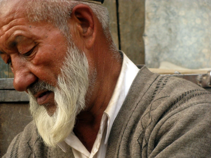 an elderly man with white hair wearing a hat