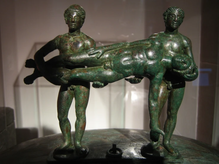 two statues of men holding each other with one carrying the other