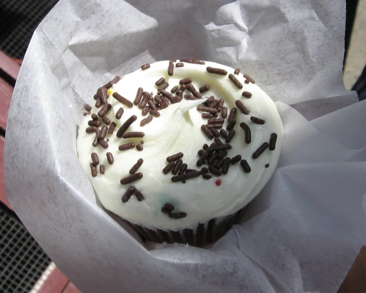 a cupcake with sprinkles on top in a wrapper