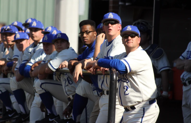 a baseball team poses for a picture in their dugout