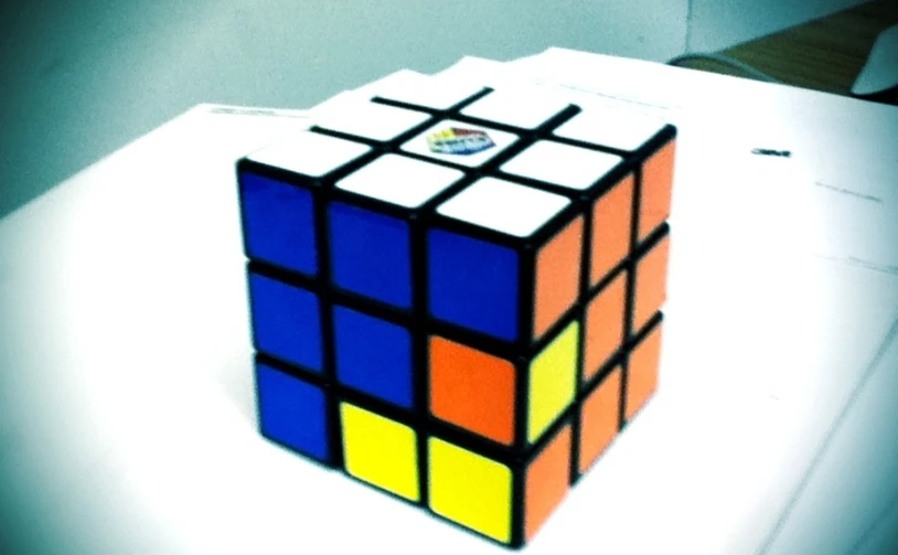 the rubik cube sits on a table next to papers