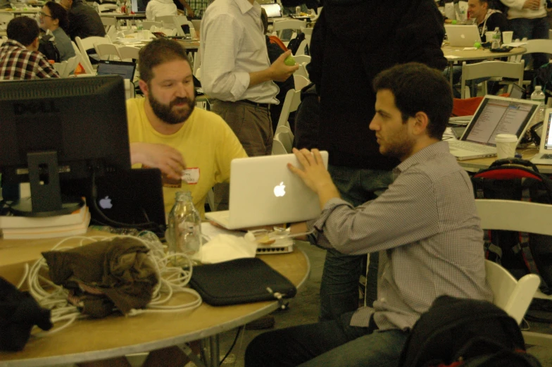 two men sitting in front of computers at a table