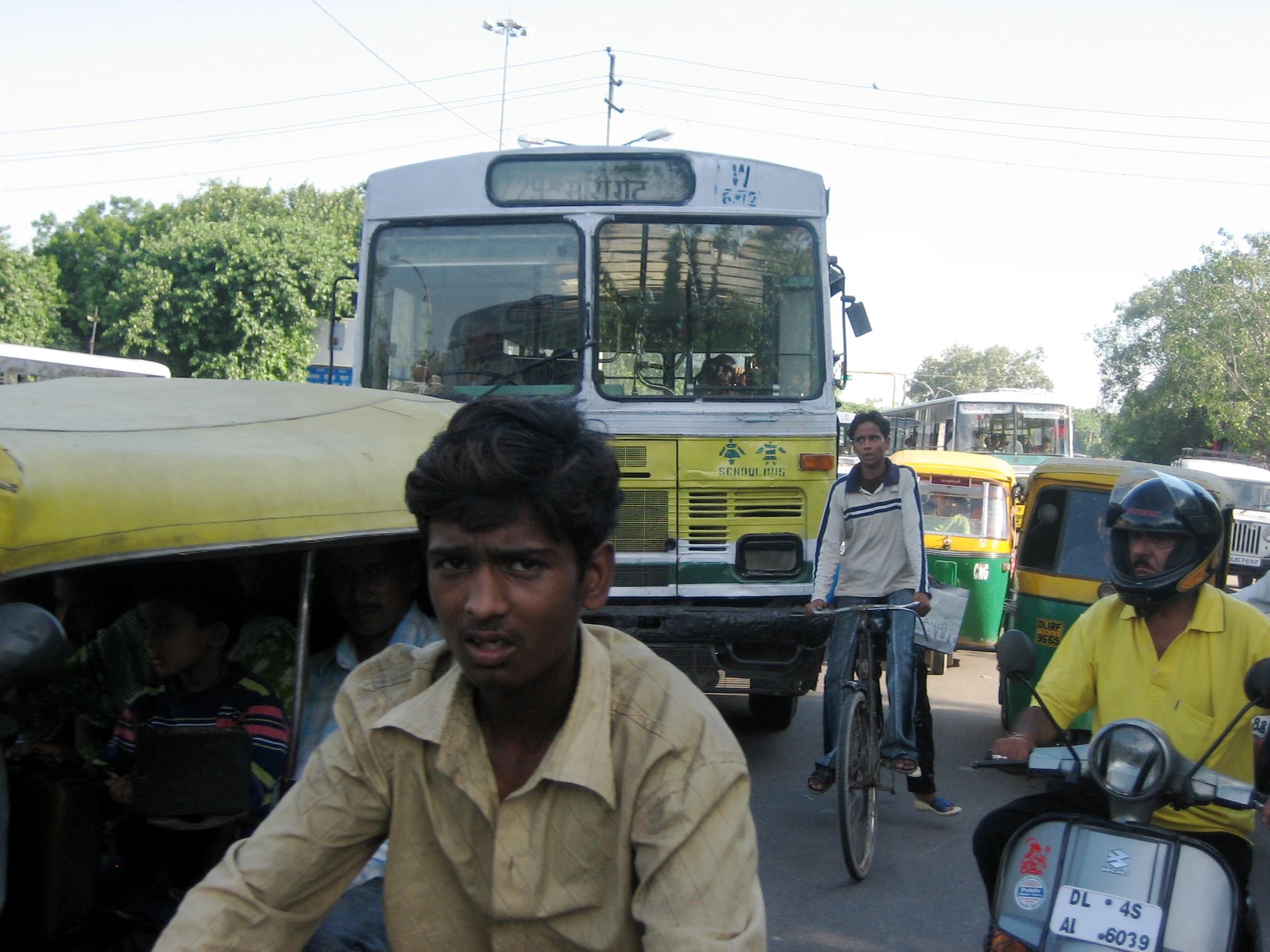 several people ride motorcycles and bicycles through the streets