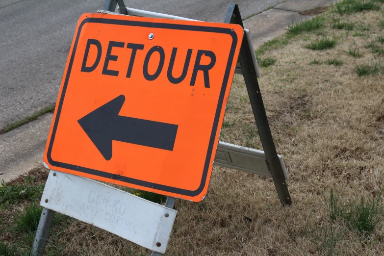 a close up of a detour sign on a street