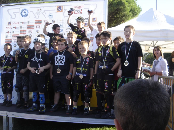 several boys are holding medals while standing on a stage