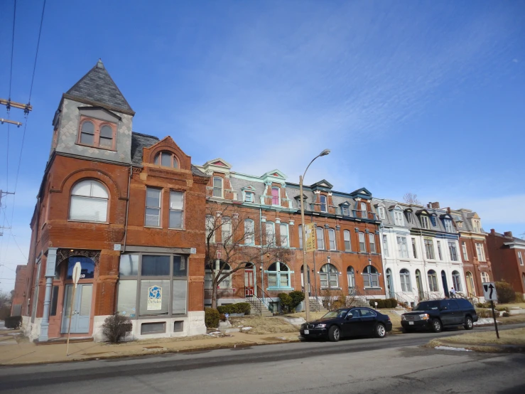 large building on the corner with several cars parked nearby