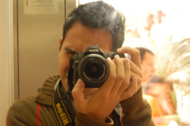 man taking selfie po in mirror with camera