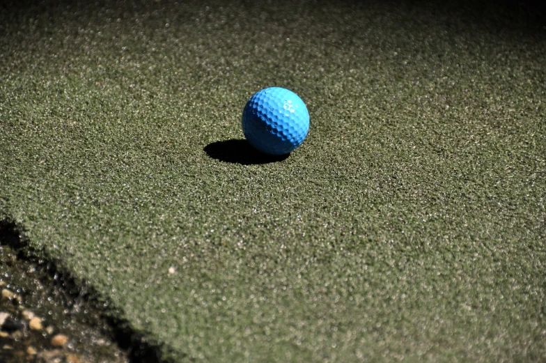 a blue golf ball sitting on a court