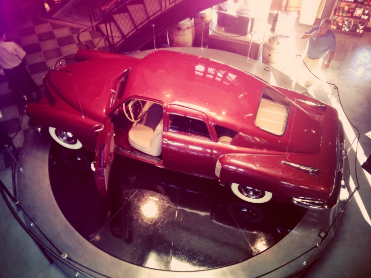 an old fashion model of an older car in a museum