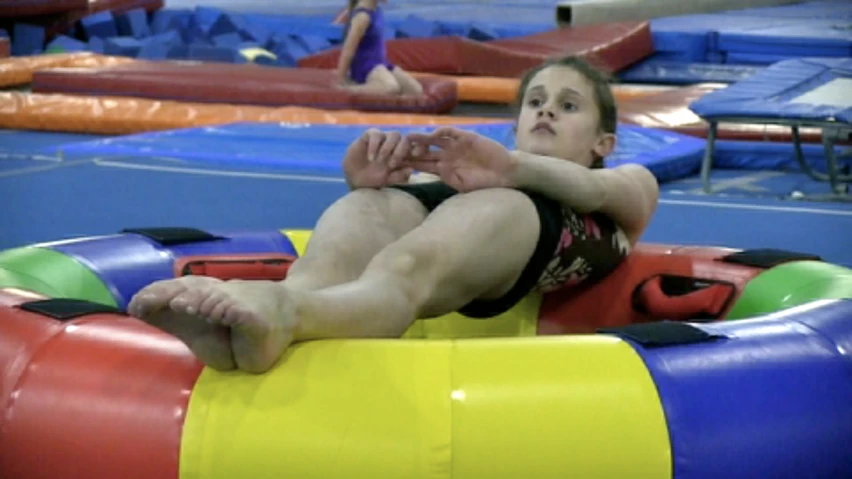a person sitting on a inflatable ball in a gym