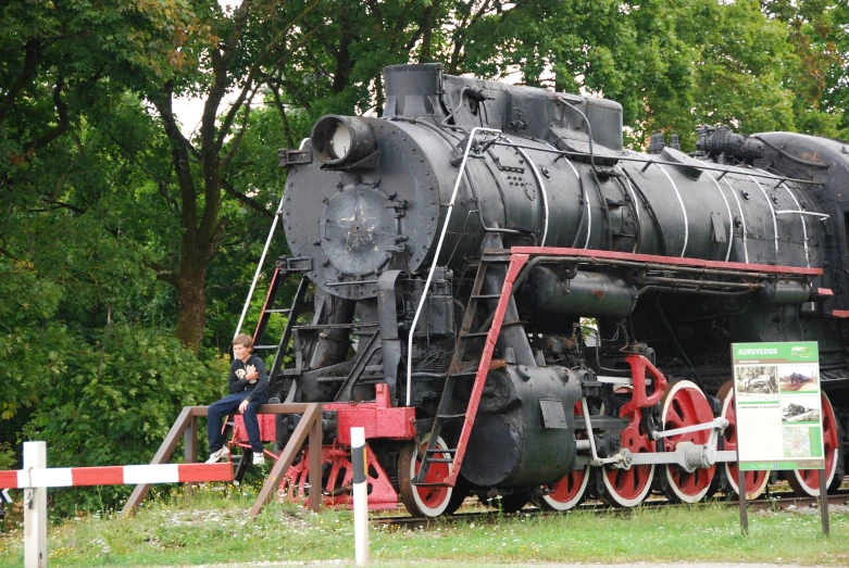 a black train sits on top of red wheels