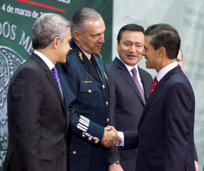 three men in suits are shaking hands with each other