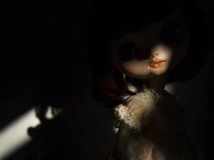 a dark room with a doll standing near by