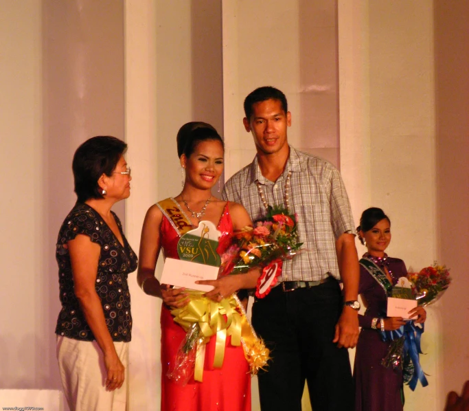 a man and woman at a competition receiving flowers