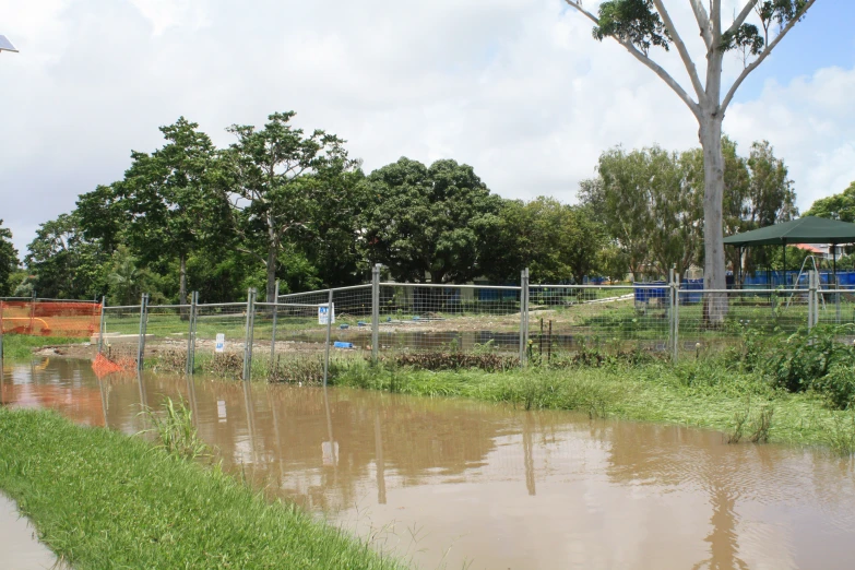 a large pond surrounded by a fenced in area