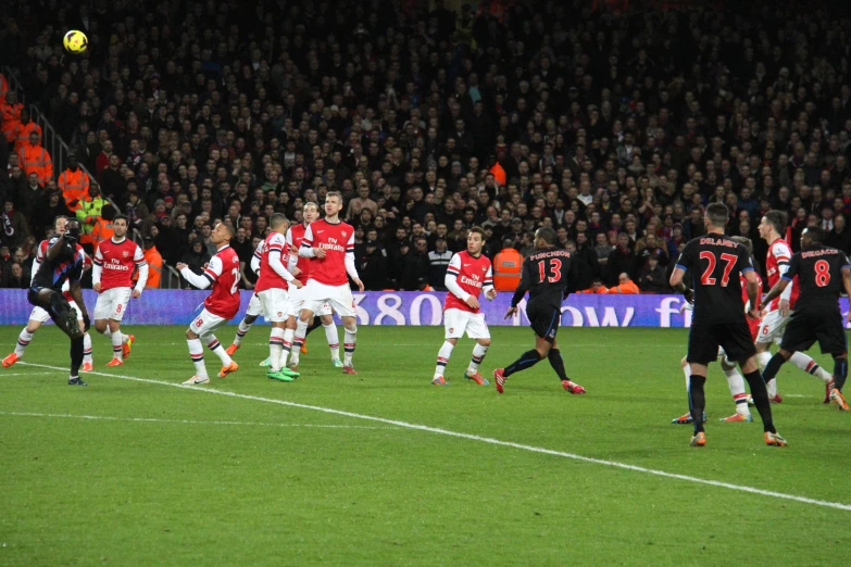 a crowd watches as the opposing soccer teams compete