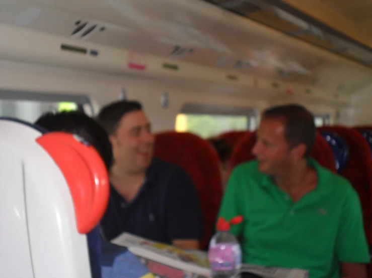 two men sitting in a airplane looking at papers