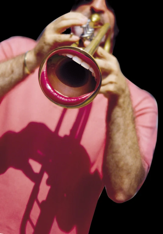 a man wearing a pink shirt is playing his trumpet