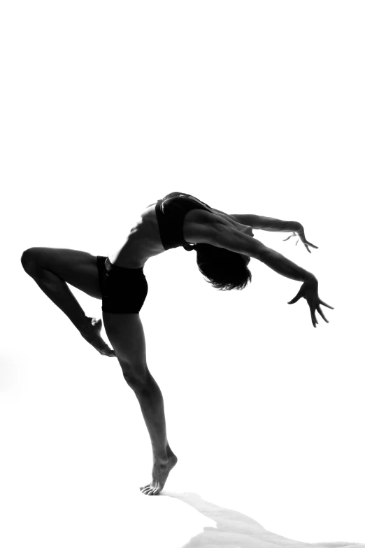 a woman is doing an acrobatic move on the beach