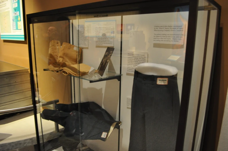 the museum case has three items on glass, and three jeans in black