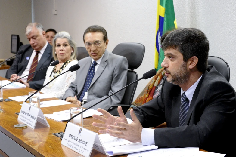 a group of people in suits sitting around a conference table