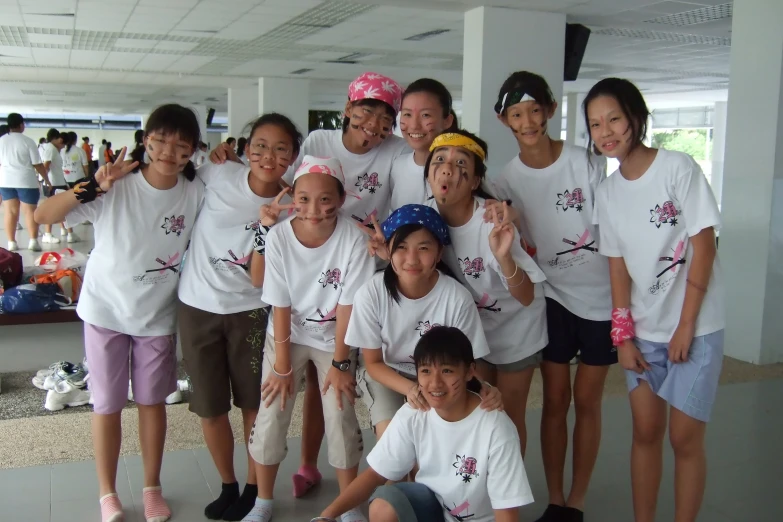 a group of children in white shirts are posing for a picture