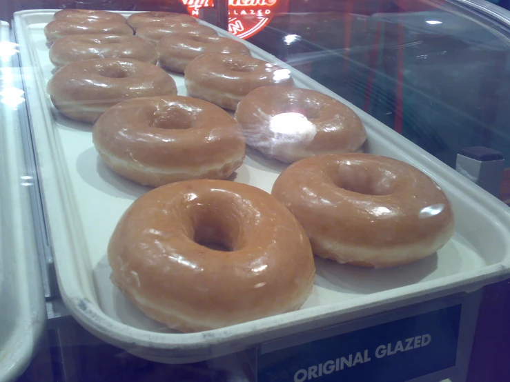 glazed donuts are shown in a display case