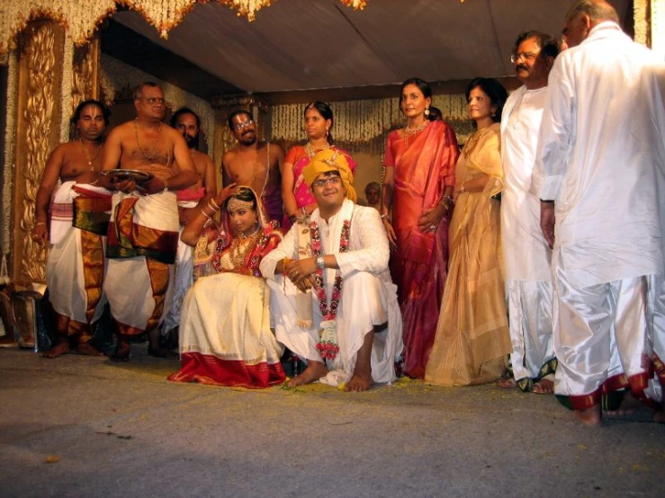 a group of people in indian garb standing in front of a stage