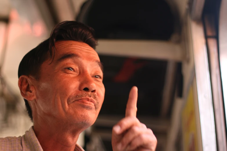 man gives a middle finger sign on a public transit bus