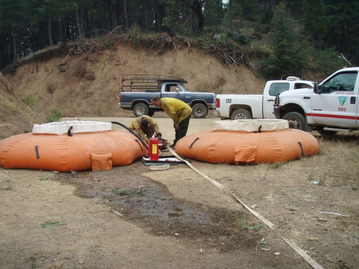 a man is working on a device outside near some trucks