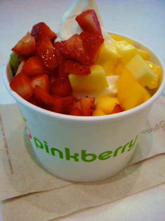 a cup filled with fruit and a plastic spoon