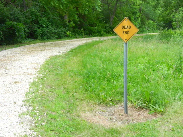 a yellow caution sign that is sitting in the grass