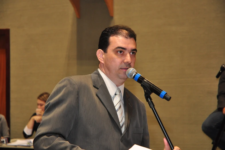 a man in a business suit speaks into a microphone