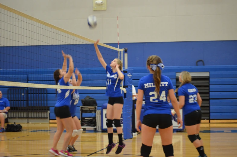 girls'volleyball team in mid - jump to hit the ball