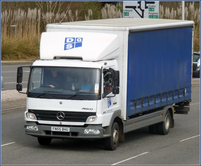 a truck driving down the street, with a white cab