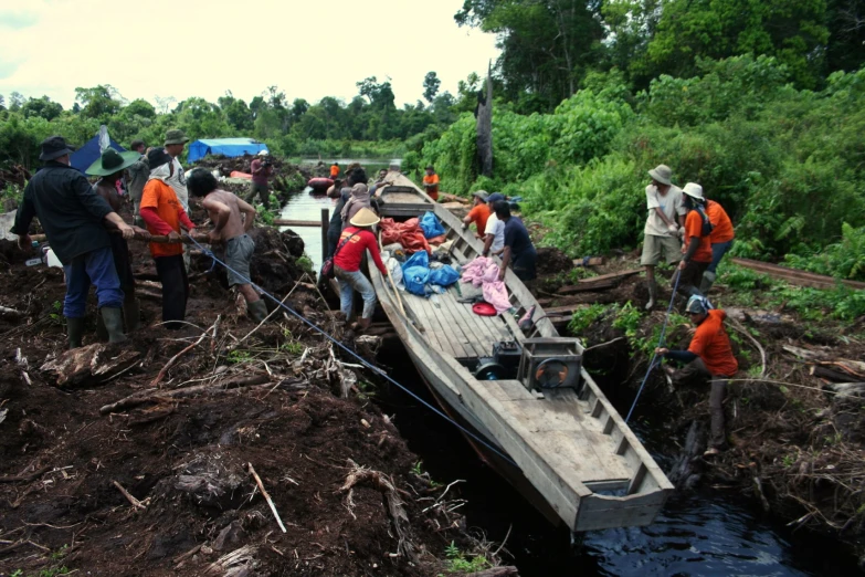 a group of people are next to a canoe