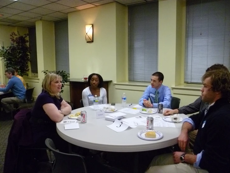 the people are sitting around the round table together