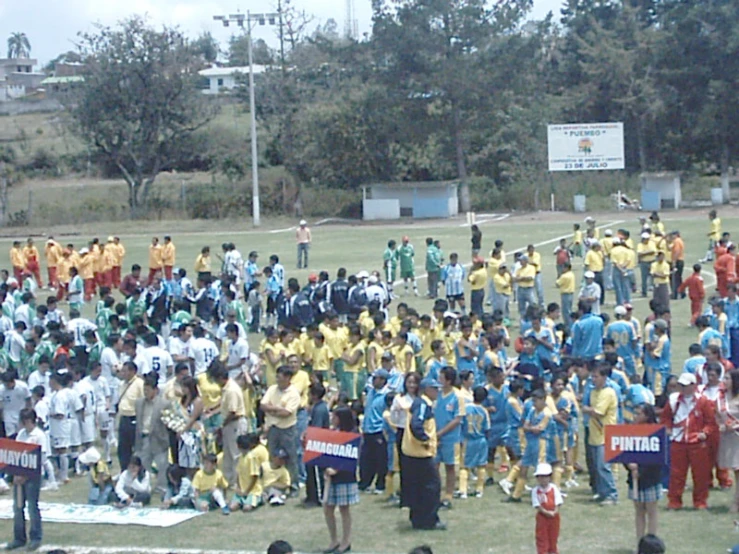 a group of children with adults gather together on the field