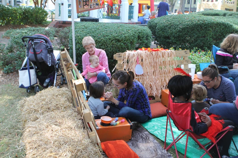 children are sitting on a hay bale in the yard