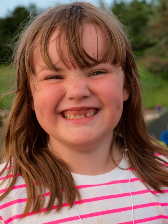 a little girl holding a donut with her hands and smiling