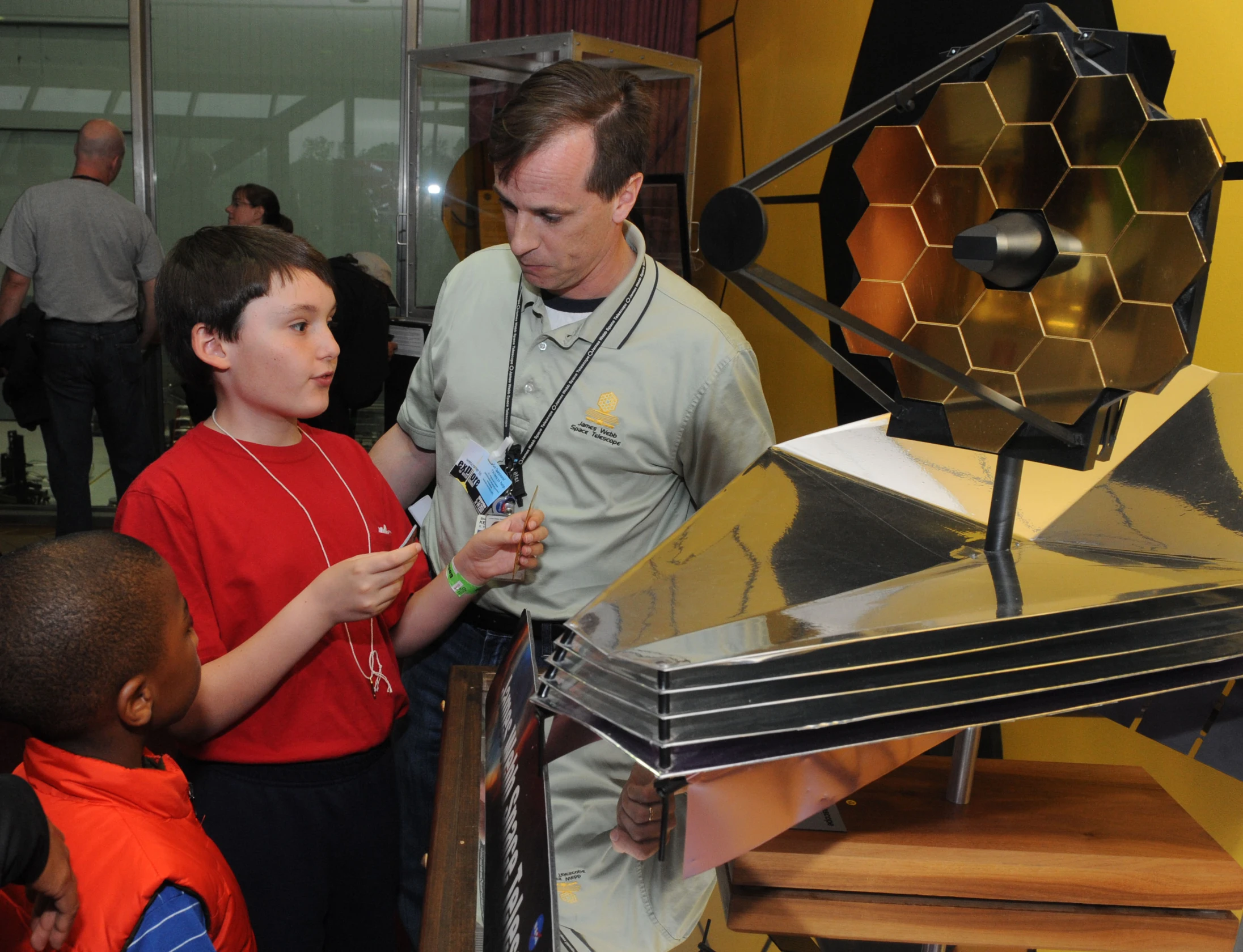 the man and two boys are looking at a large object