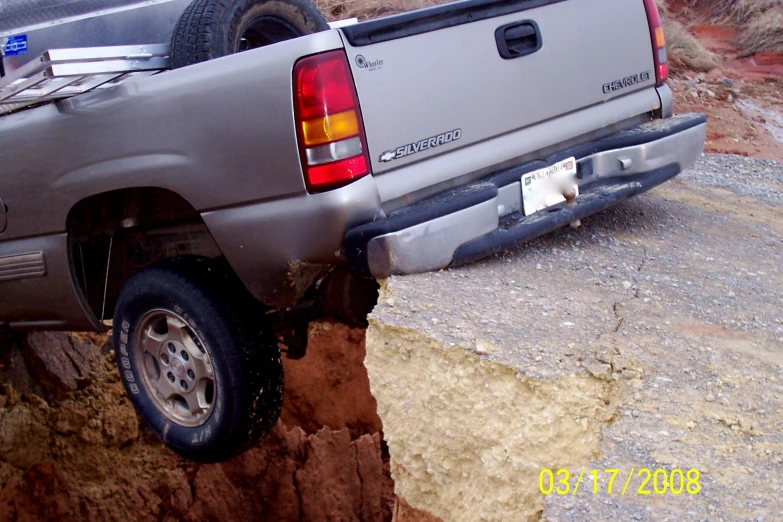 a pickup truck stuck into a cliff on the road