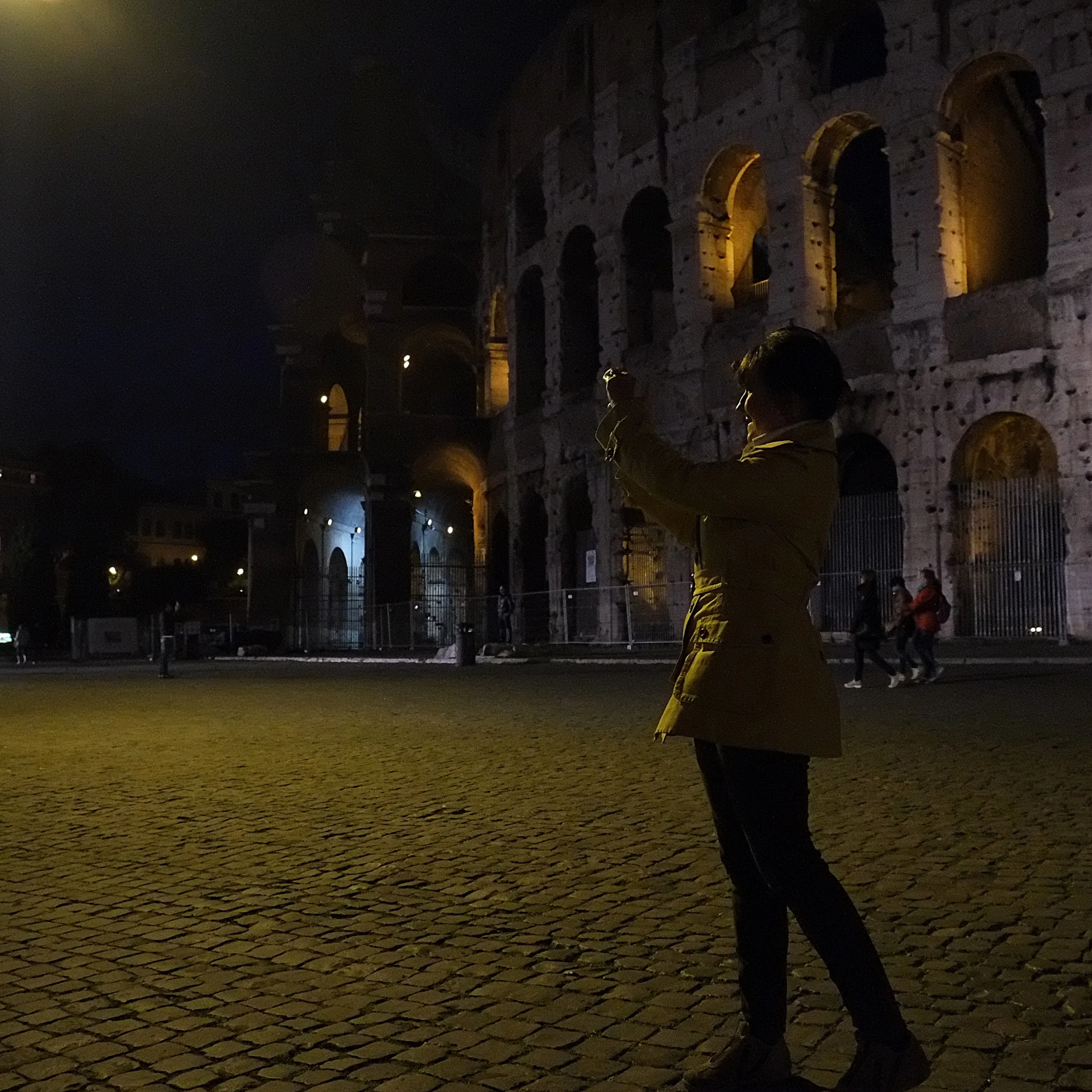 woman with umbrella standing on stone floor by building